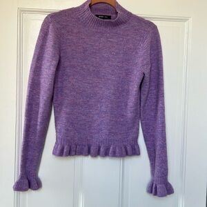 Lavender sweater with ruffle hem and fluted sleeves.